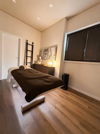 Lettino massaggi con coperta morbida e luce soffusa nella cabina relax